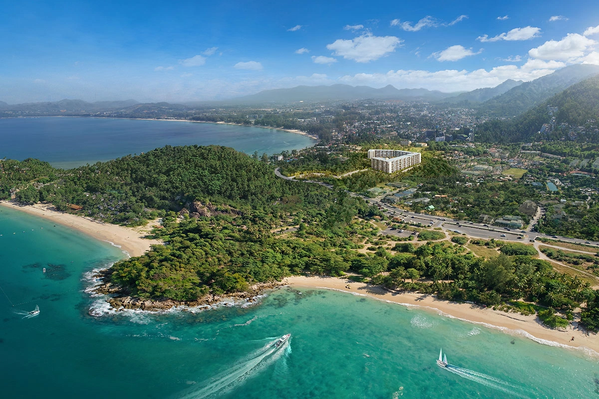 The west coast from above: two bays with sandy beaches, a green headland between them and the project's buildings on the slope