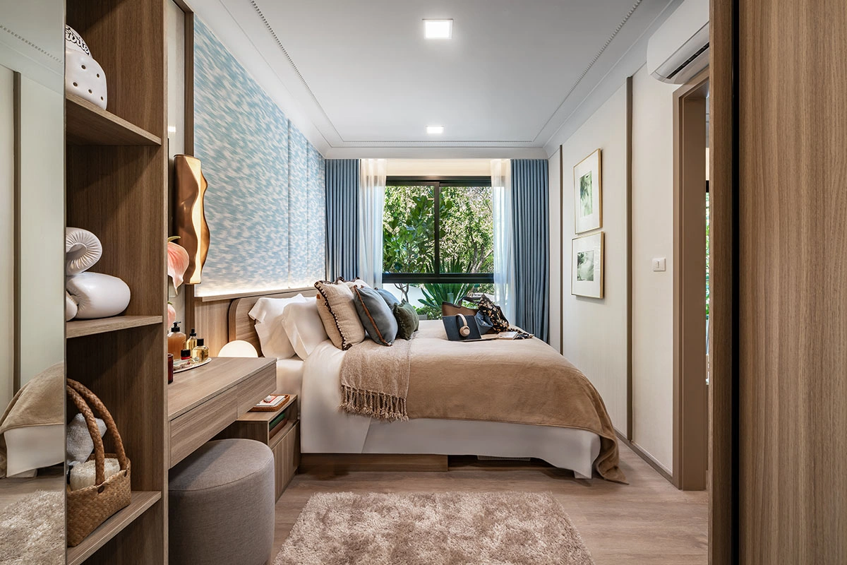A bedroom: the bed by a full-height window, a dressing table with a display cabinet and blue curtains