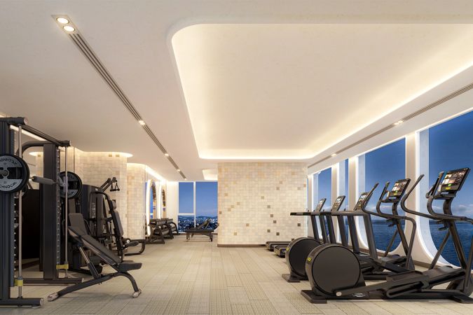 Gym: силовые тренажёры вдоль стены, беговые дорожки и эллипсоиды у арочных окон, за окнами море
