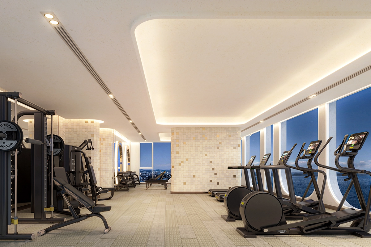 Gym: силовые тренажёры вдоль стены, беговые дорожки и эллипсоиды у арочных окон, за окнами море