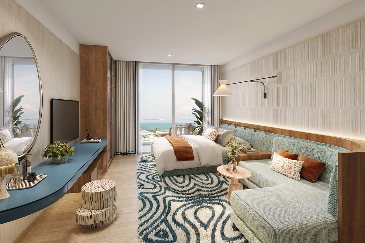 Шоу-рум планировки, где комната подписана BEDROOM & LIVING AREA: кровать и диван в одном объёме, длинная синяя консоль с зеркалом, дверь на балкон с видом на море