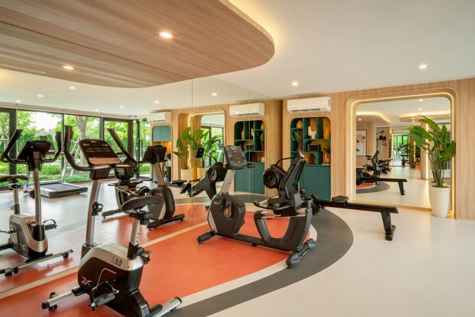 Кардиозона: велотренажёры и гребной тренажёр перед зеркалами, деревянный подшивной потолок волной