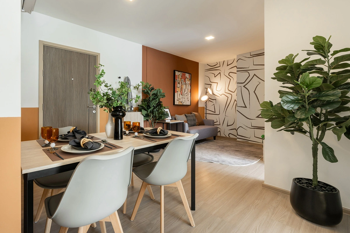 The dining area by the entrance: a table for four, the front door on the left and, beyond the table, the sofa against the patterned wall