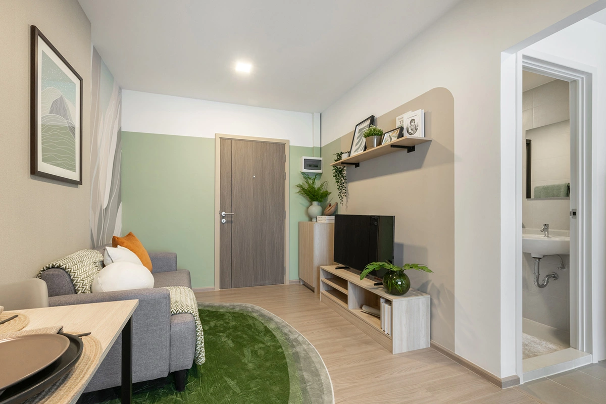 The same room from the window: sofa and rug on the left, the television unit on the right and, through the opening, the bathroom with its basin