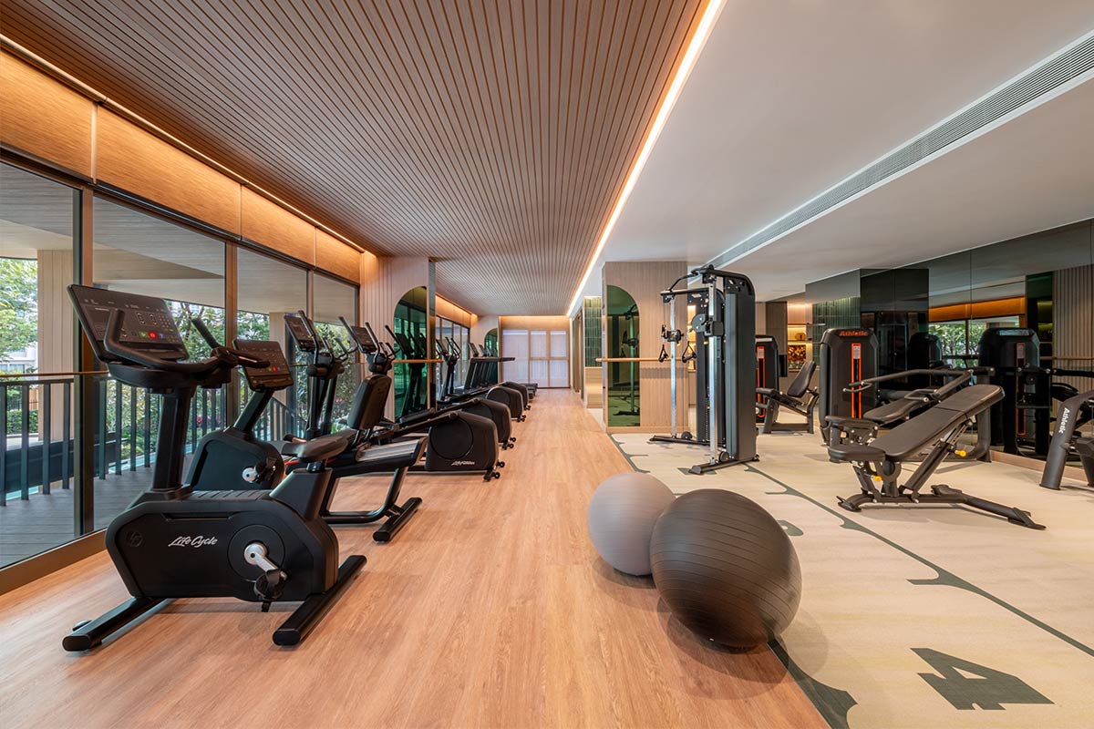 The gym: a Life Fitness row at the window onto the garden — an upright bike, then recumbent bikes and treadmills; opposite, Athletic strength machines, adjustable benches and a cable station