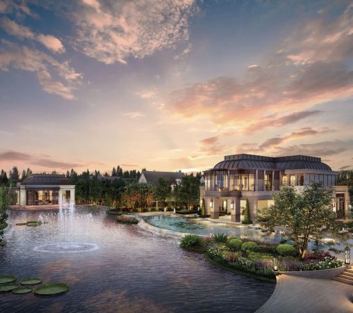 The clubhouse on the far bank of the lake at dusk, with fountains at the near edge of the water