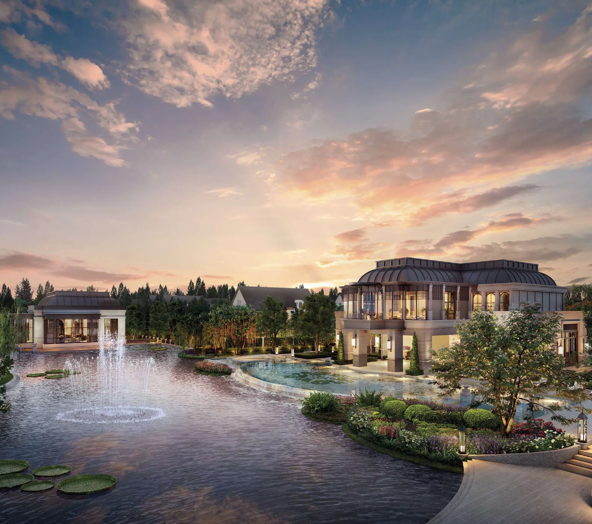 The clubhouse on the far bank of the lake at dusk, with fountains at the near edge of the water