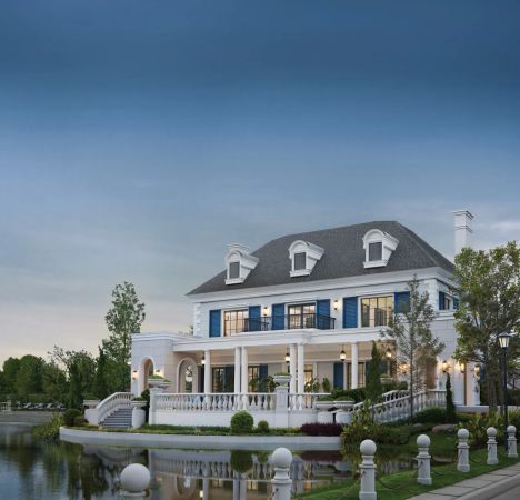 The same clubhouse at dusk: dormer windows, shutters and the bridge over the water