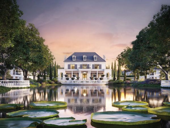 The clubhouse across the lake at dusk, water lilies at the near edge