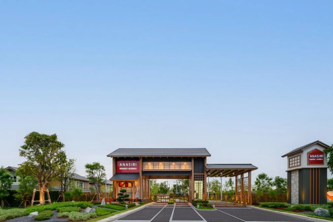 The entrance gate: a deep roof overhang, timber posts and the project sign
