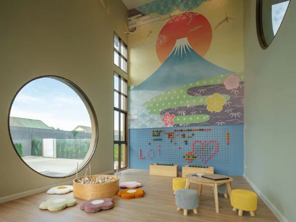 The children's room: a round window, low poufs and a wall painted with Mount Fuji