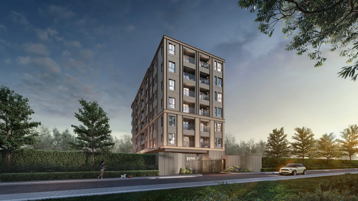 The building from the lane: seven storeys, brick cladding, trees along the drive