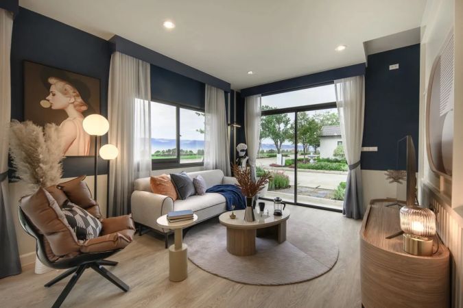 A living room from the developer's brochure: a full-height window facing the estate