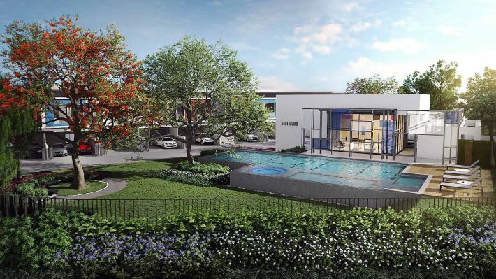 The clubhouse with its pool, lawn and paths in front