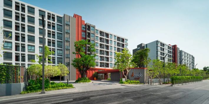The entrance from the street: white and red façades, the dcondo sign by the road