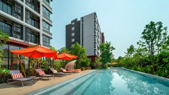 The pool between the buildings, parasols and loungers along the walkway