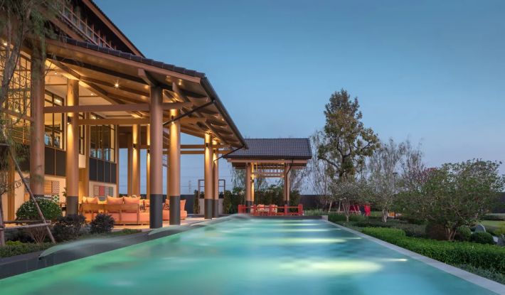 The pool beneath its timber pavilion in the evening