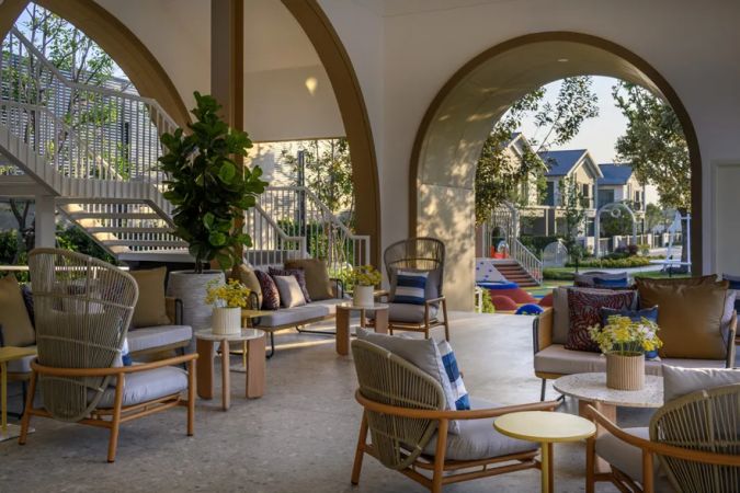 The clubhouse terrace under the arches, chairs and a view of the development