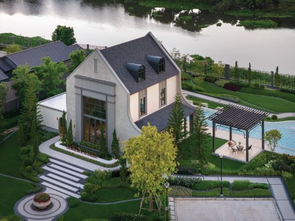 The clubhouse on the bank: water, a walkway and the pool beside it