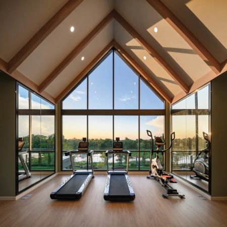 The gym under a high pitch with full-height glazing onto the water