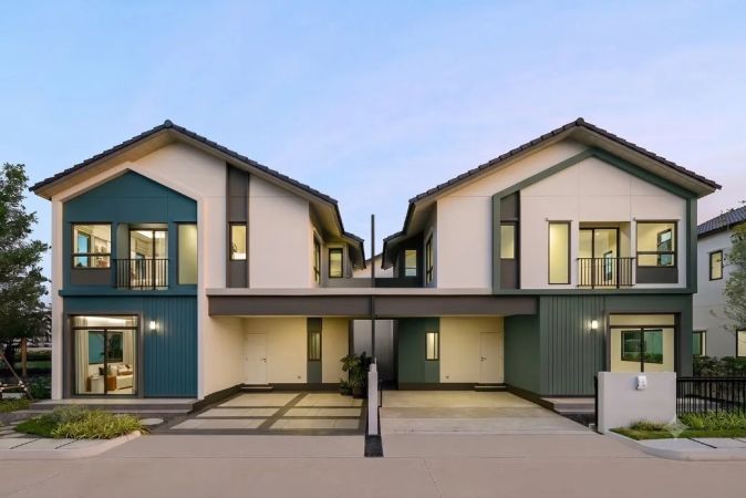A pair of semi-detached houses with dark green panels