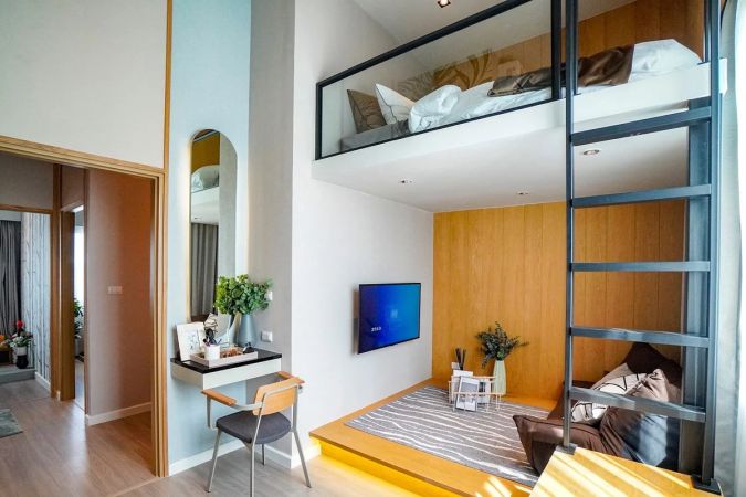 A bedroom with a mezzanine bed under the raised ceiling