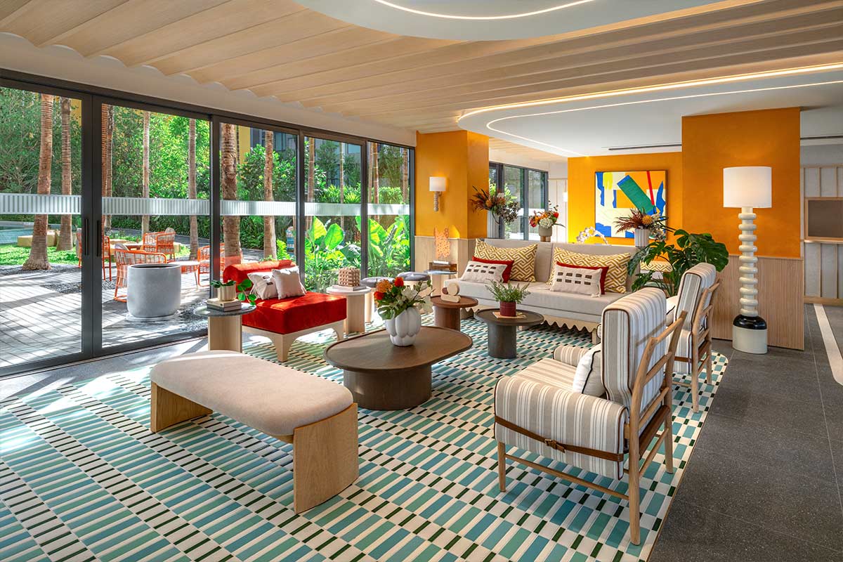 Communal lounge: sofas and armchairs, a striped rug and full-height windows onto the garden