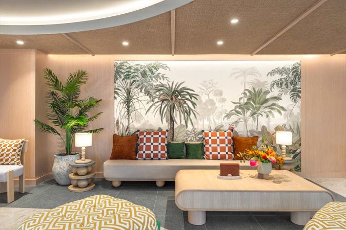 Lobby seating area: a low sofa against a wall with a tropical mural