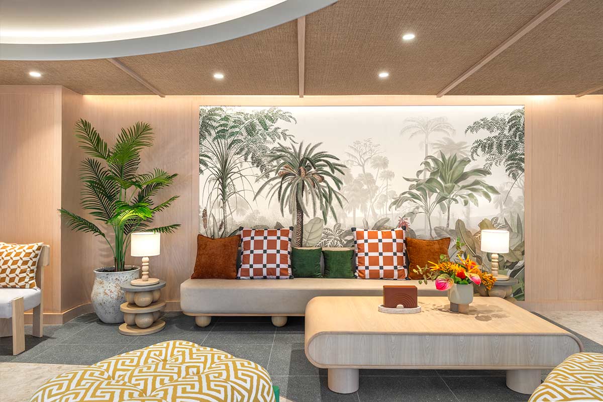 Lobby seating area: a low sofa against a wall with a tropical mural