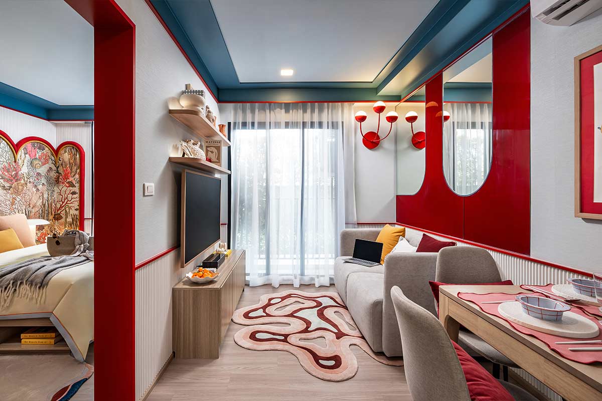 Show unit: living room with a TV and a dining table, the bedroom through the opening