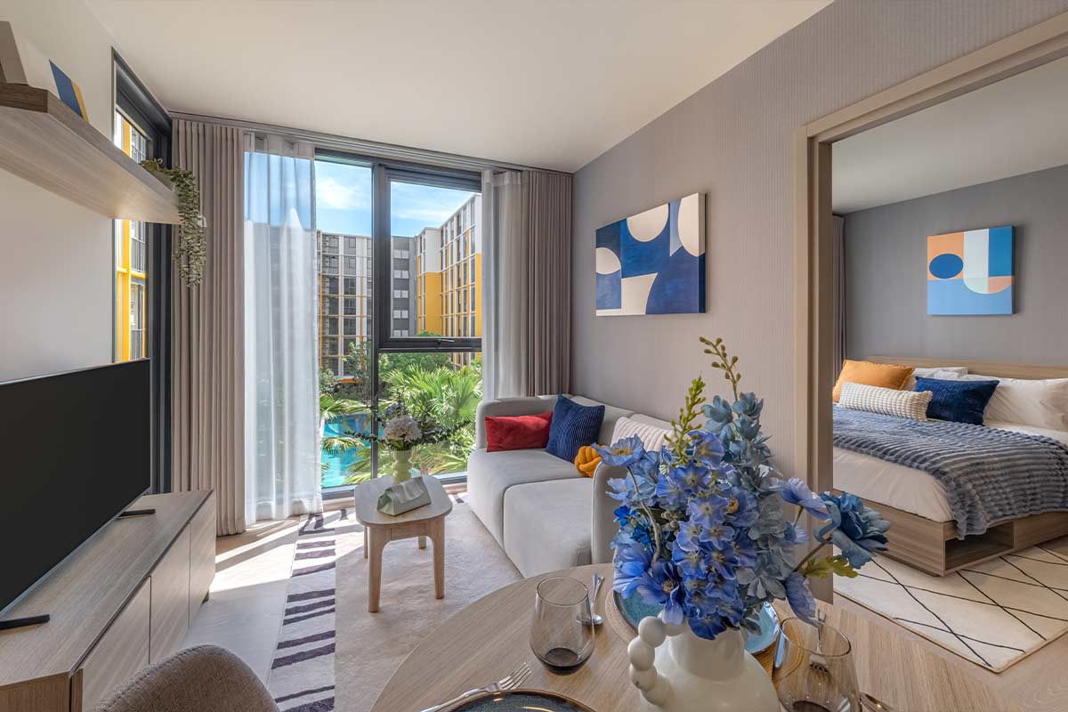 Living room opening onto the balcony, with a view of the pool and the neighbouring building
