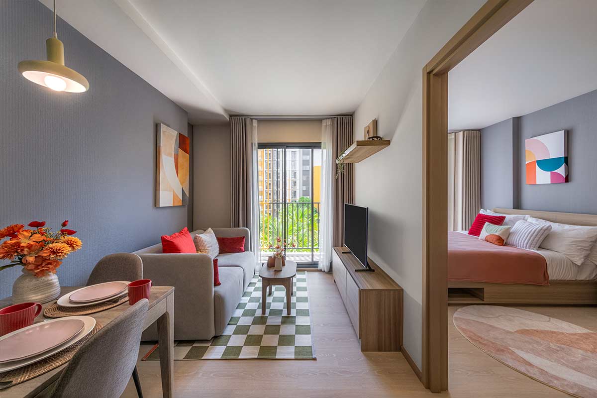 Living room with a dining area and a separate bedroom through the opening