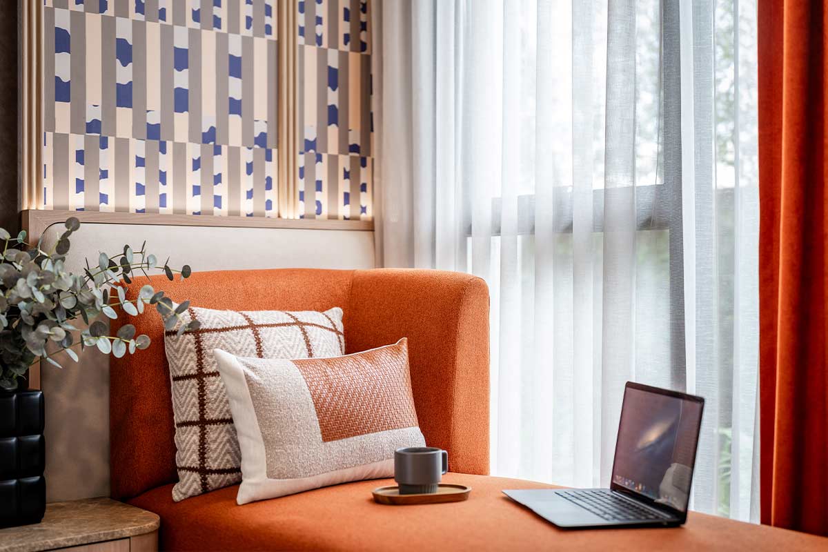 A work corner in the unit: a daybed by the window with a laptop