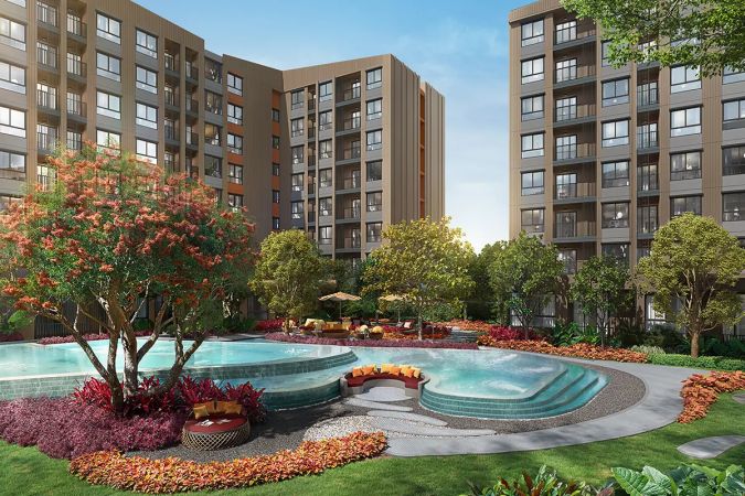 The round jacuzzi beside the pool, surrounded by lawn and flower beds with the buildings behind