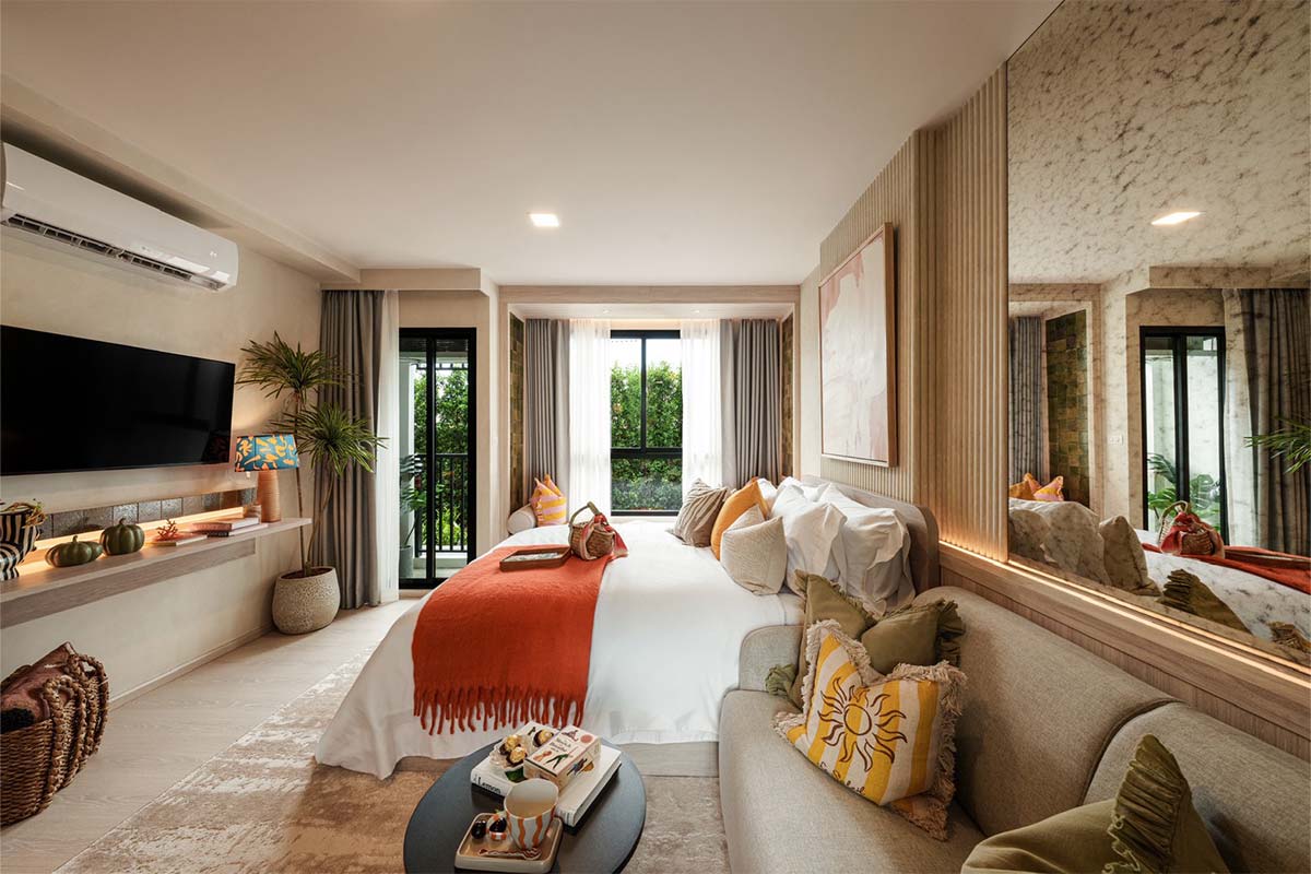 Show unit: the bed and the sofa in one room, a TV on the wall and a door to the balcony