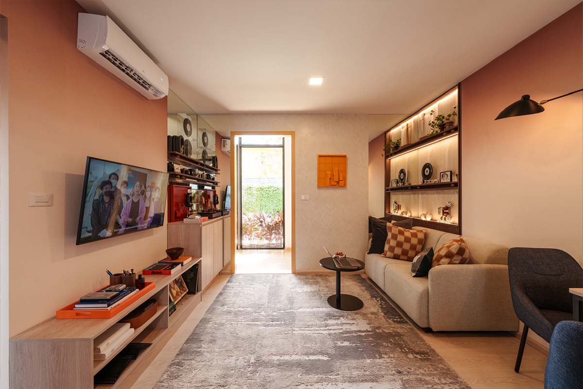 Show unit: a long living room with a TV and lit shelving, with a glazed door to the outside at the far end