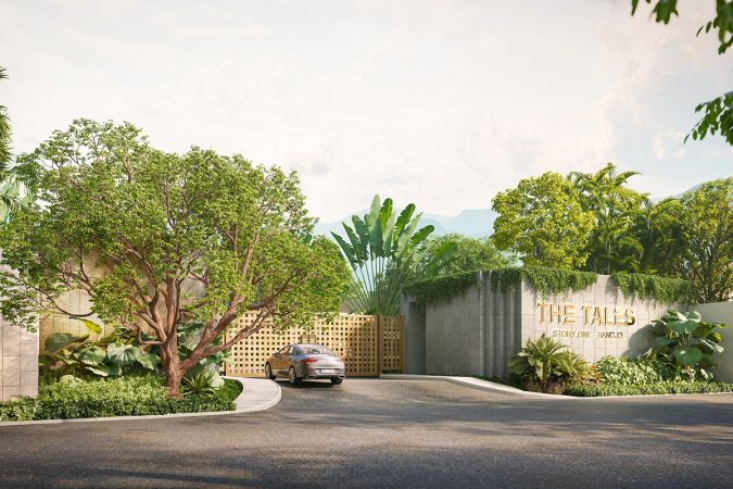 The same entrance from the side: a car at the latticed gates, the concrete wall with the project name in gold and trailing ivy on the right, a spreading tree on the left