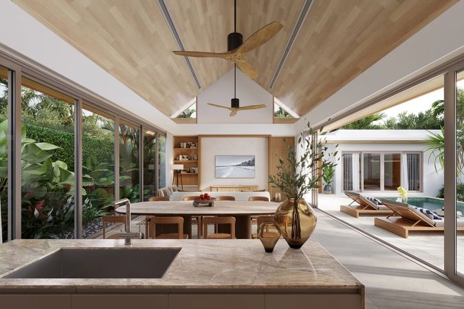 The view from the kitchen island: a gabled timber ceiling over the dining table, loungers by the water through the opening
