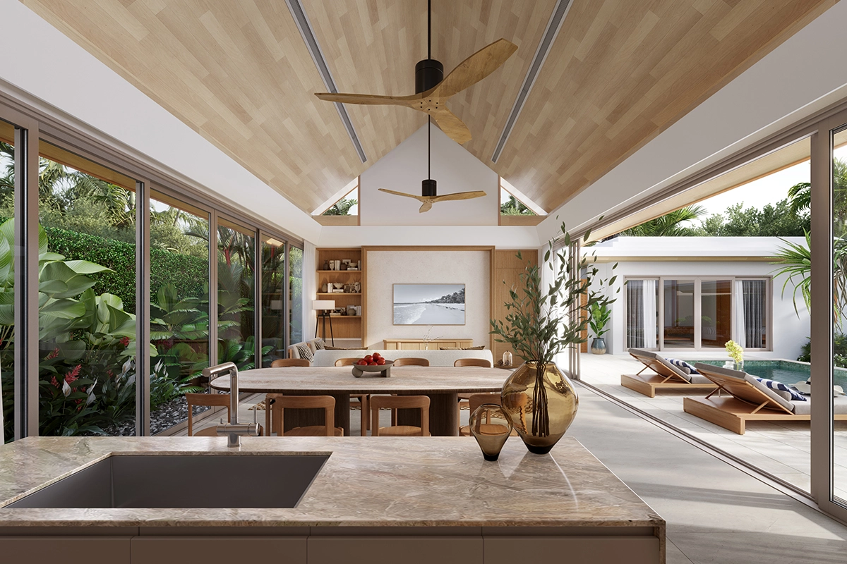 The view from the kitchen island: a gabled timber ceiling over the dining table, loungers by the water through the opening