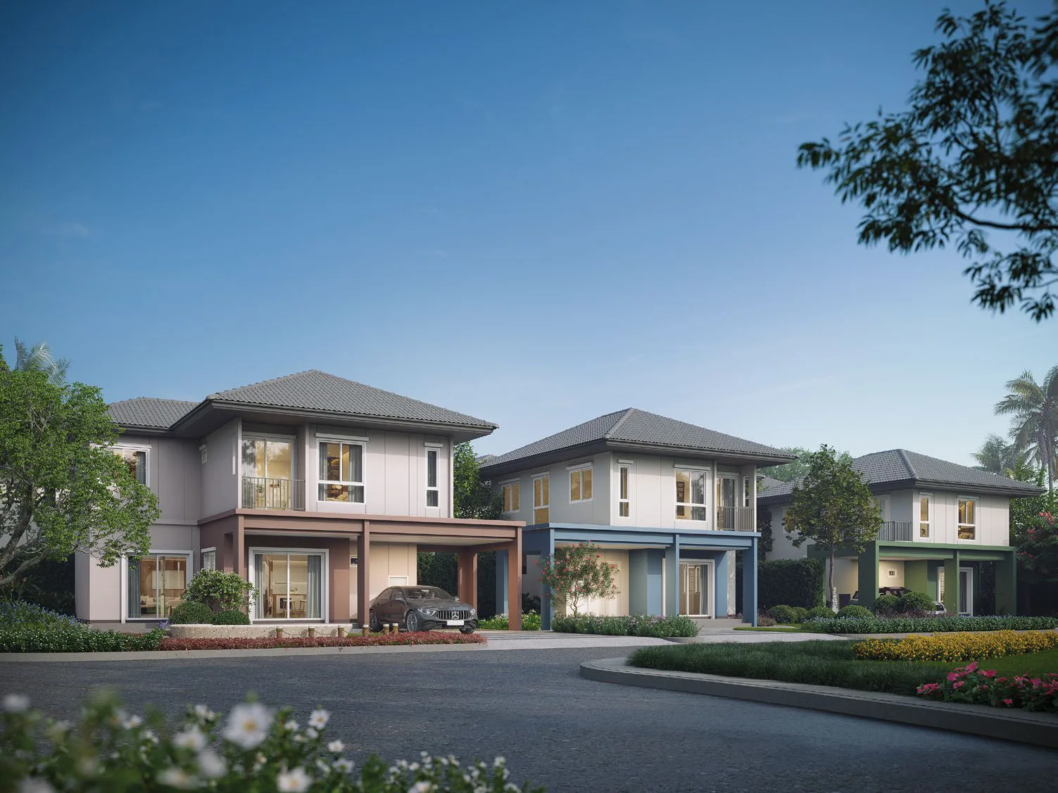 A street in the estate: three two-storey homes in a row under hipped tiled roofs, each with a two-car carport in its own colour — pink, blue, green