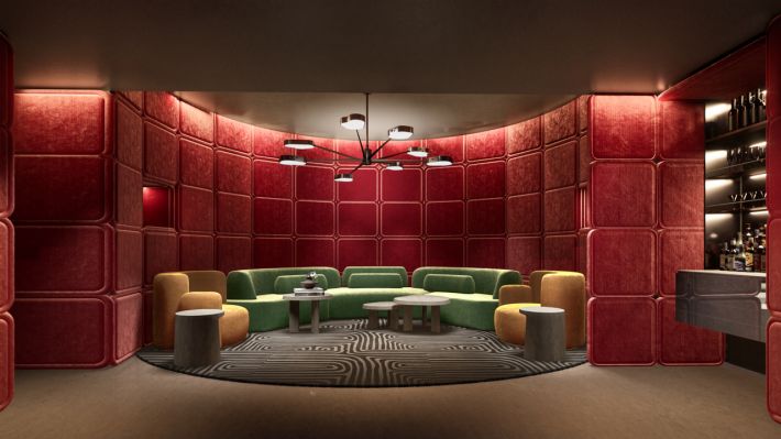 The private cinema: walls in red quilted panels, green sofas and a minibar to the right