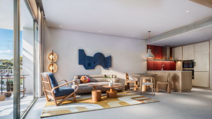 The one-bedroom: the living room with a blue wall panel and the island kitchen to the right